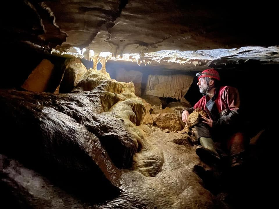 Paul Martin inside a cave looking towards the daylight at the entrance