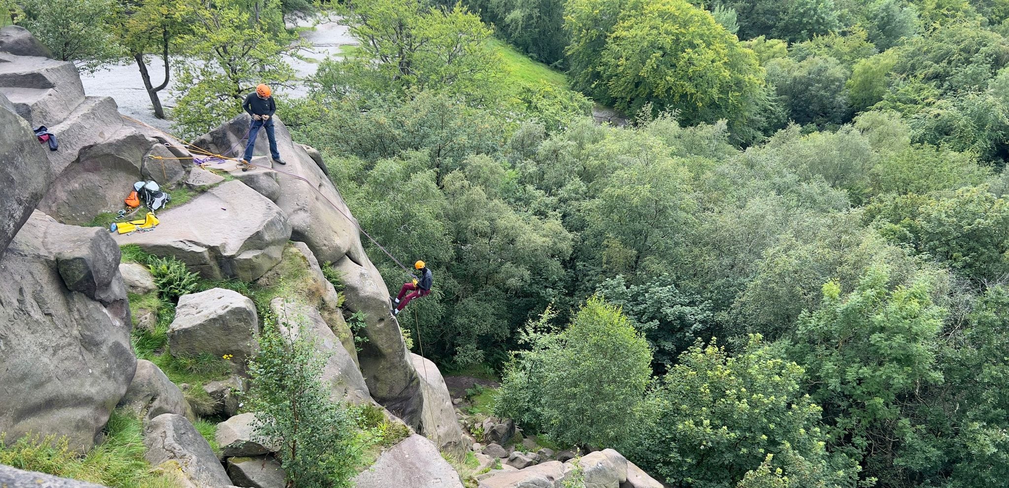 Paul Martin supervising a young person abseiling at Black Rocks in Derbyshire